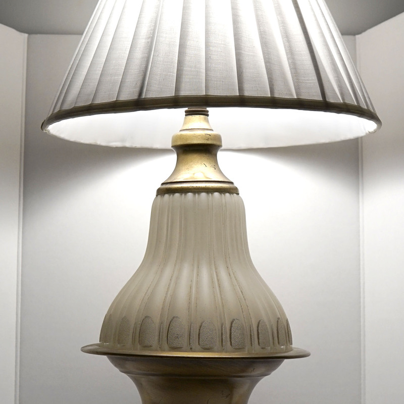 A vintage brass and frosted glass lamp